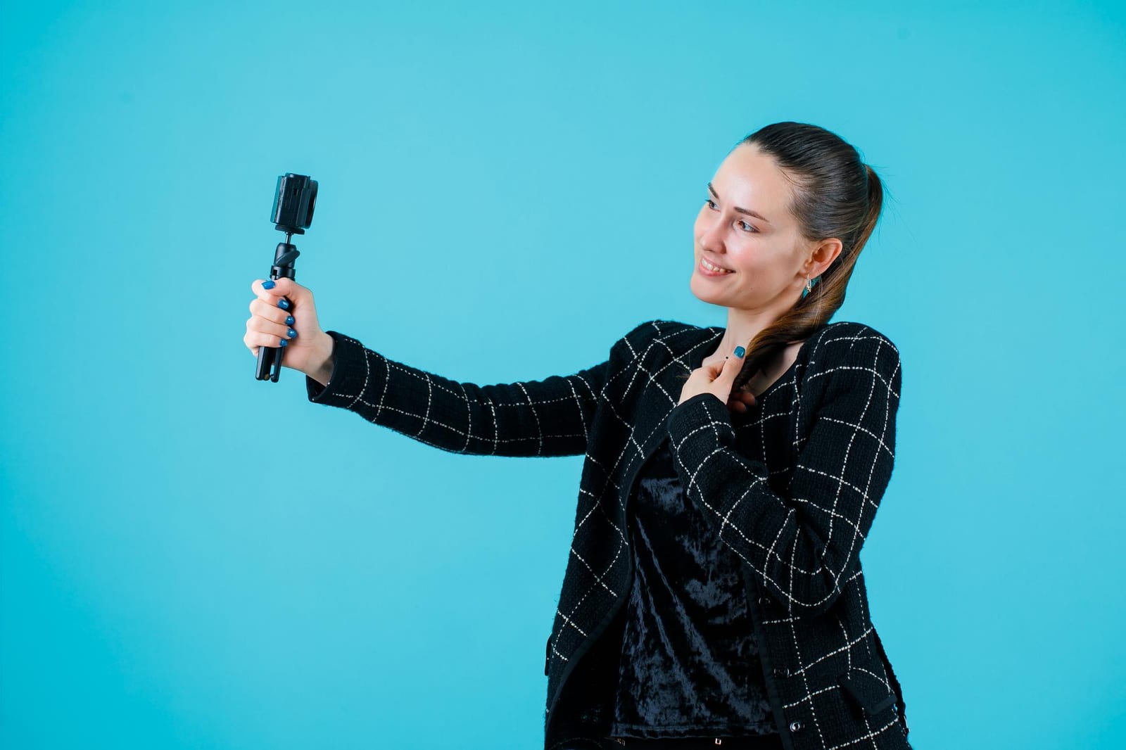 A journalist holding a small camera close to her chest